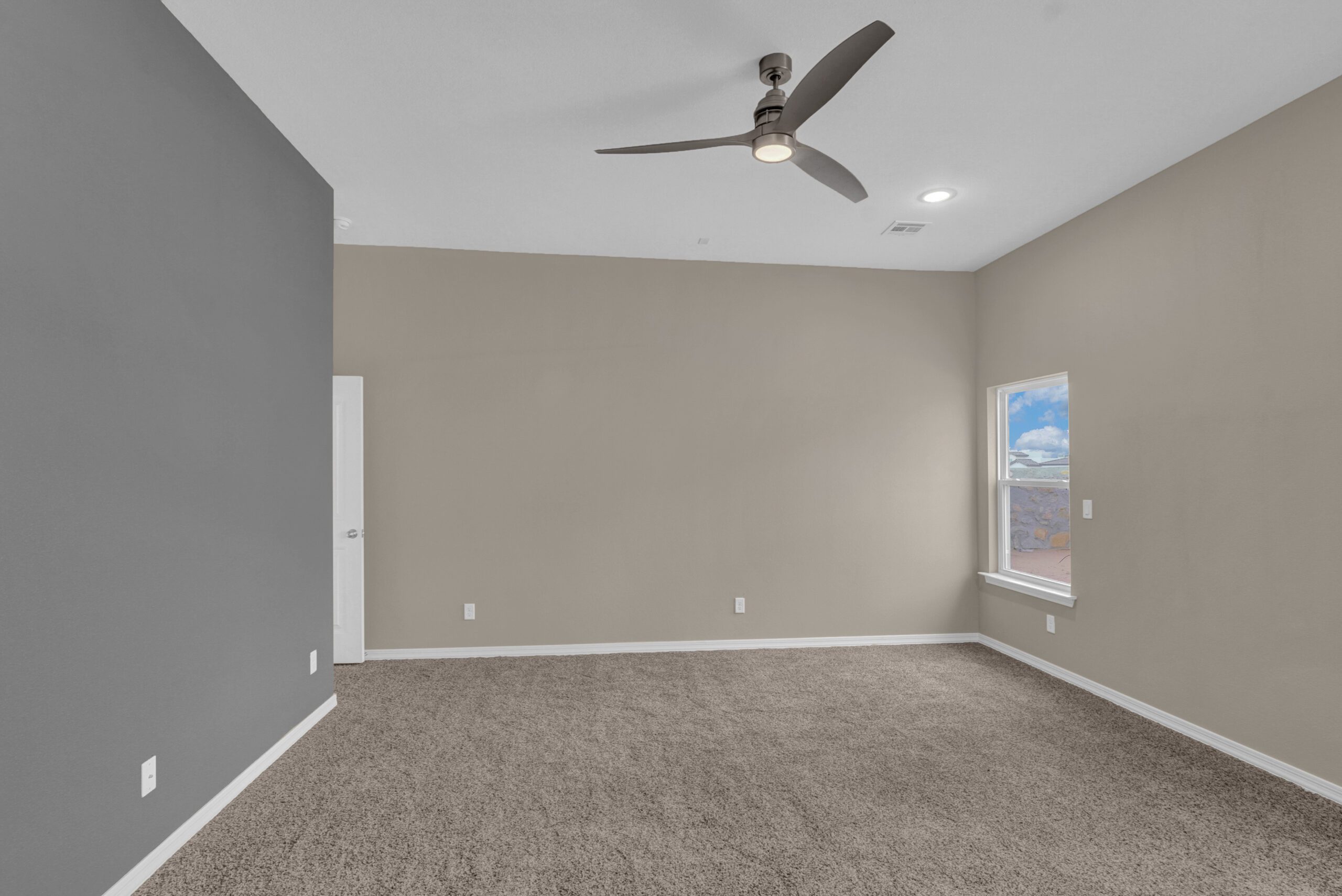 Bedroom in The Paprika model with neutral tones and modern ceiling fan