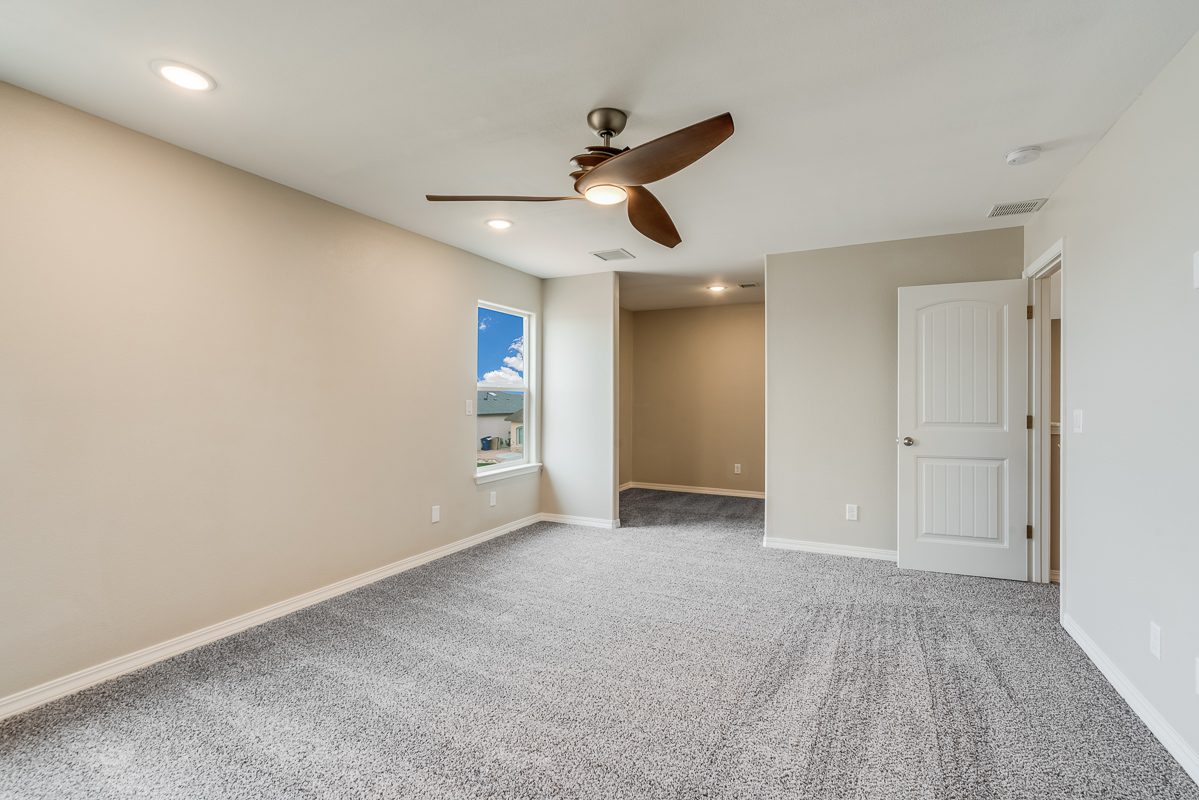 The Chiffon primary bedroom with neutral walls, plush carpet flooring, modern ceiling fan, recessed lighting, and large window providing natural light.