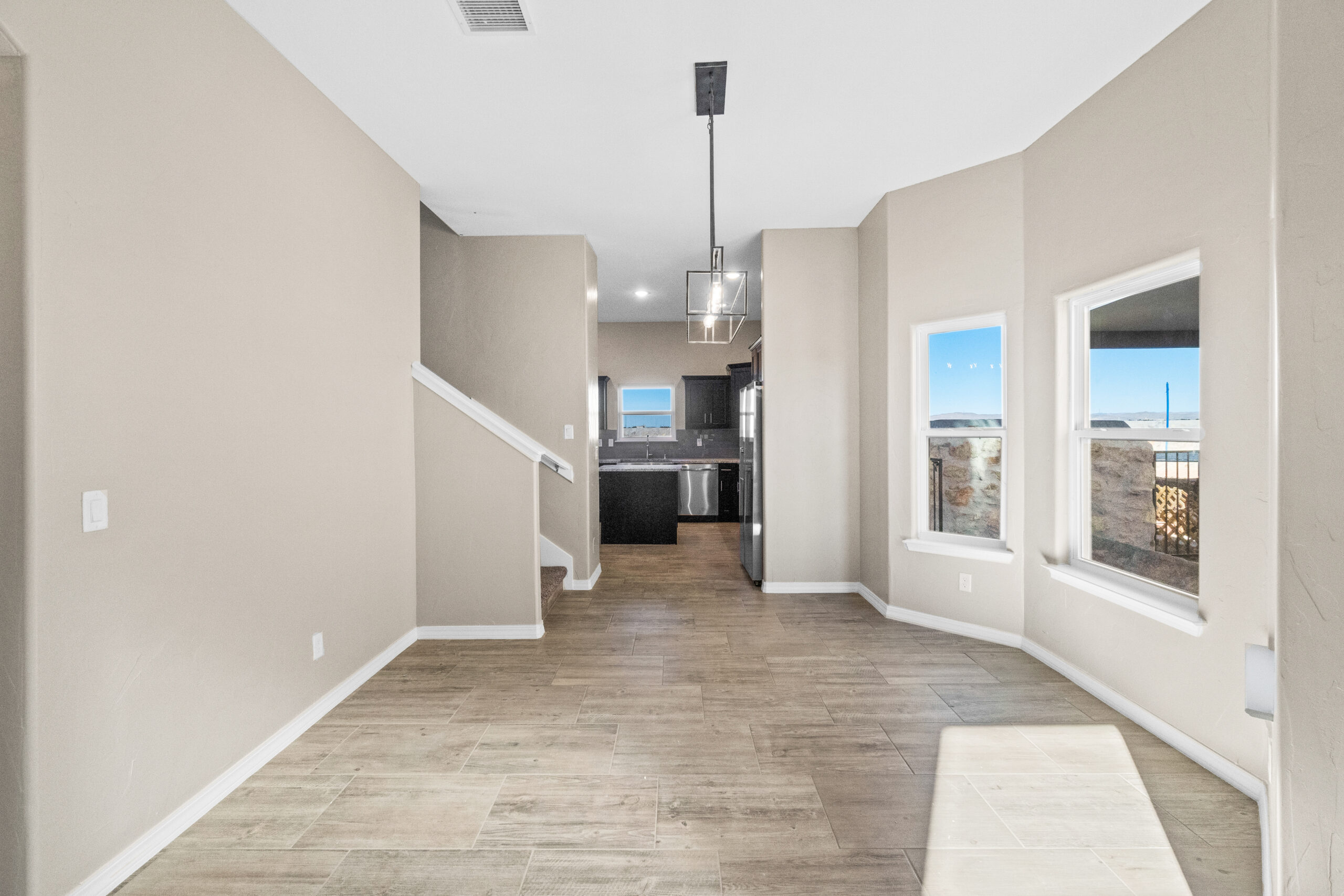 Open-concept view of The Trellis kitchen and dining area with natural light, large windows, and tile flooring.