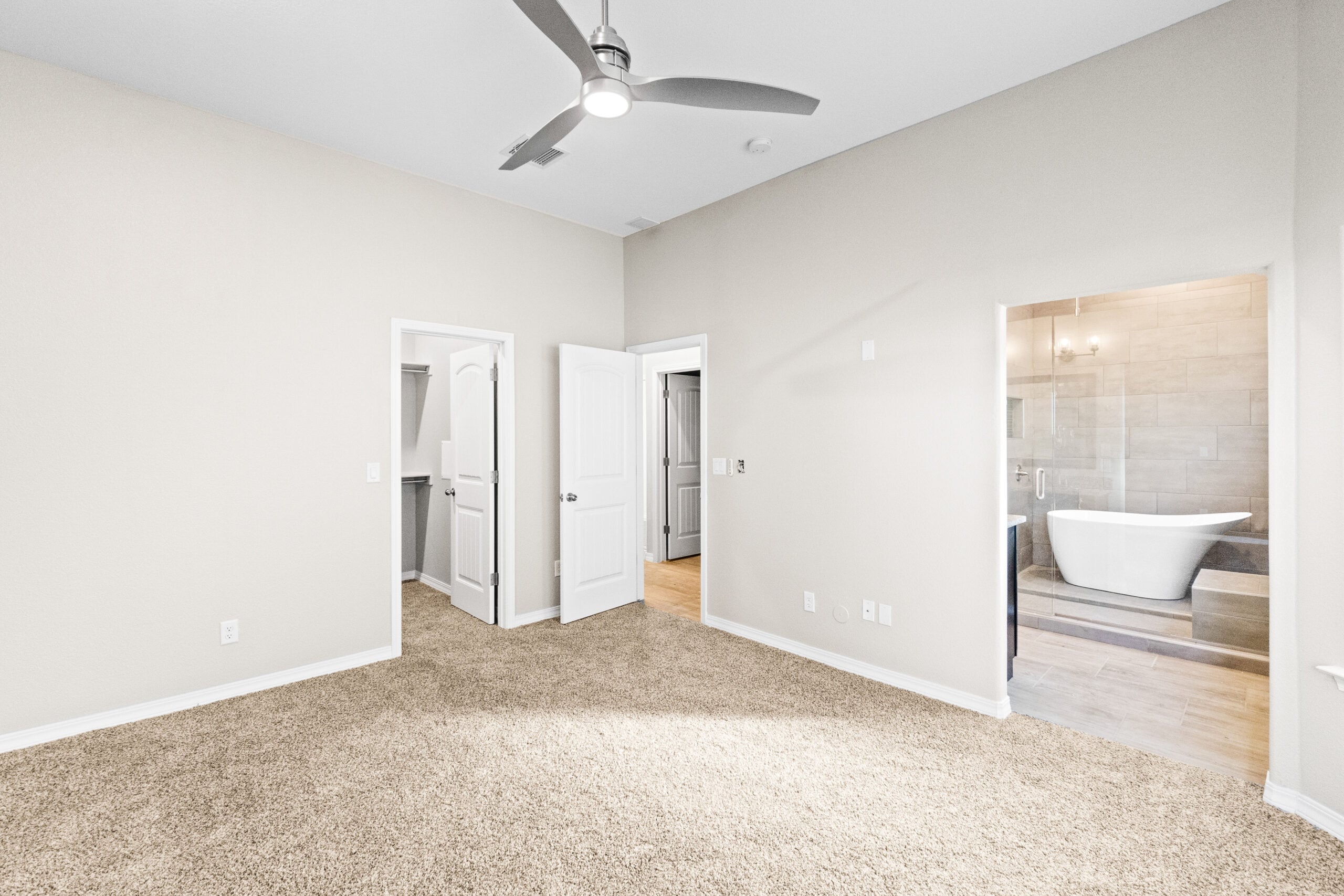 Primary bedroom in The Trellis model with view of freestanding tub and walk-in shower.