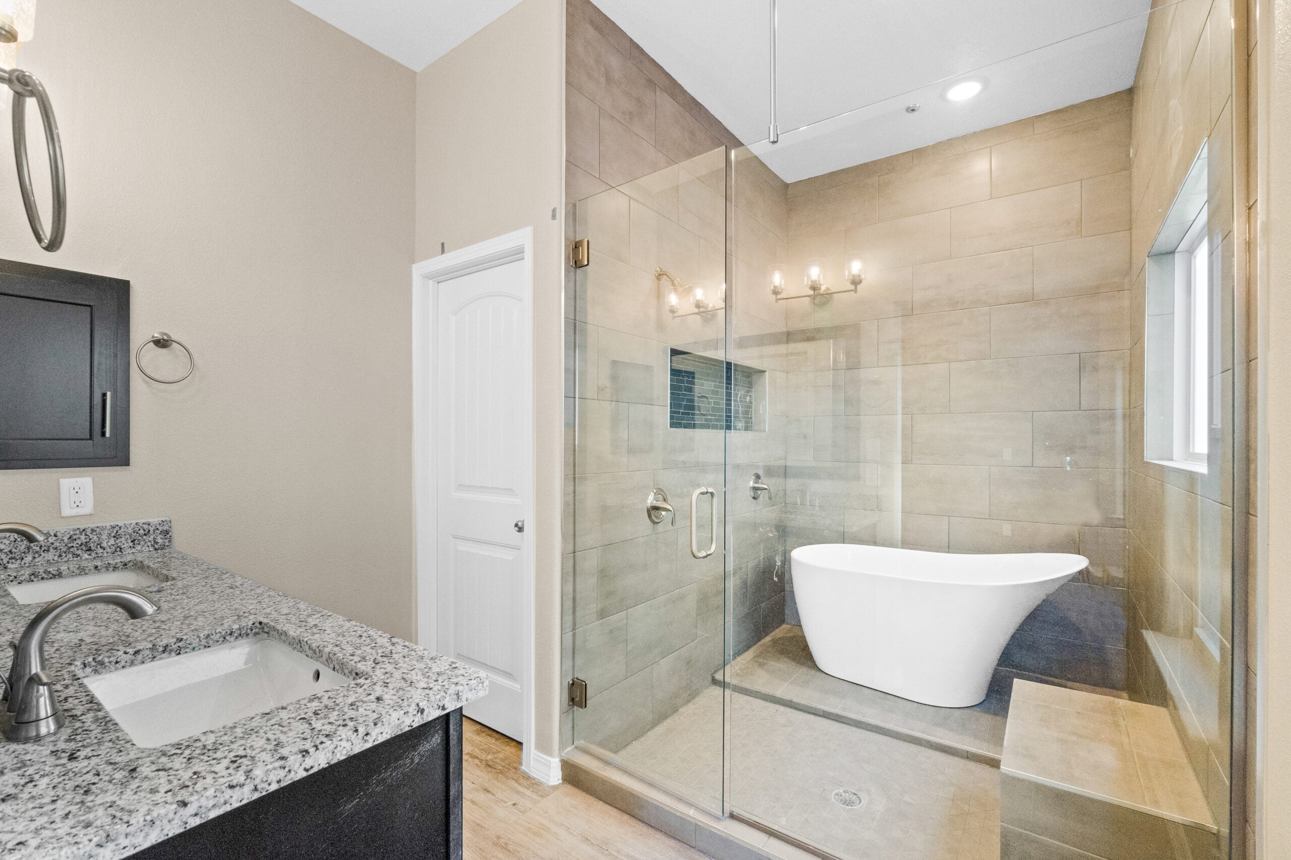 Freestanding bathtub and walk-in shower with glass enclosure in The Trellis primary bathroom by Zia Homes.
