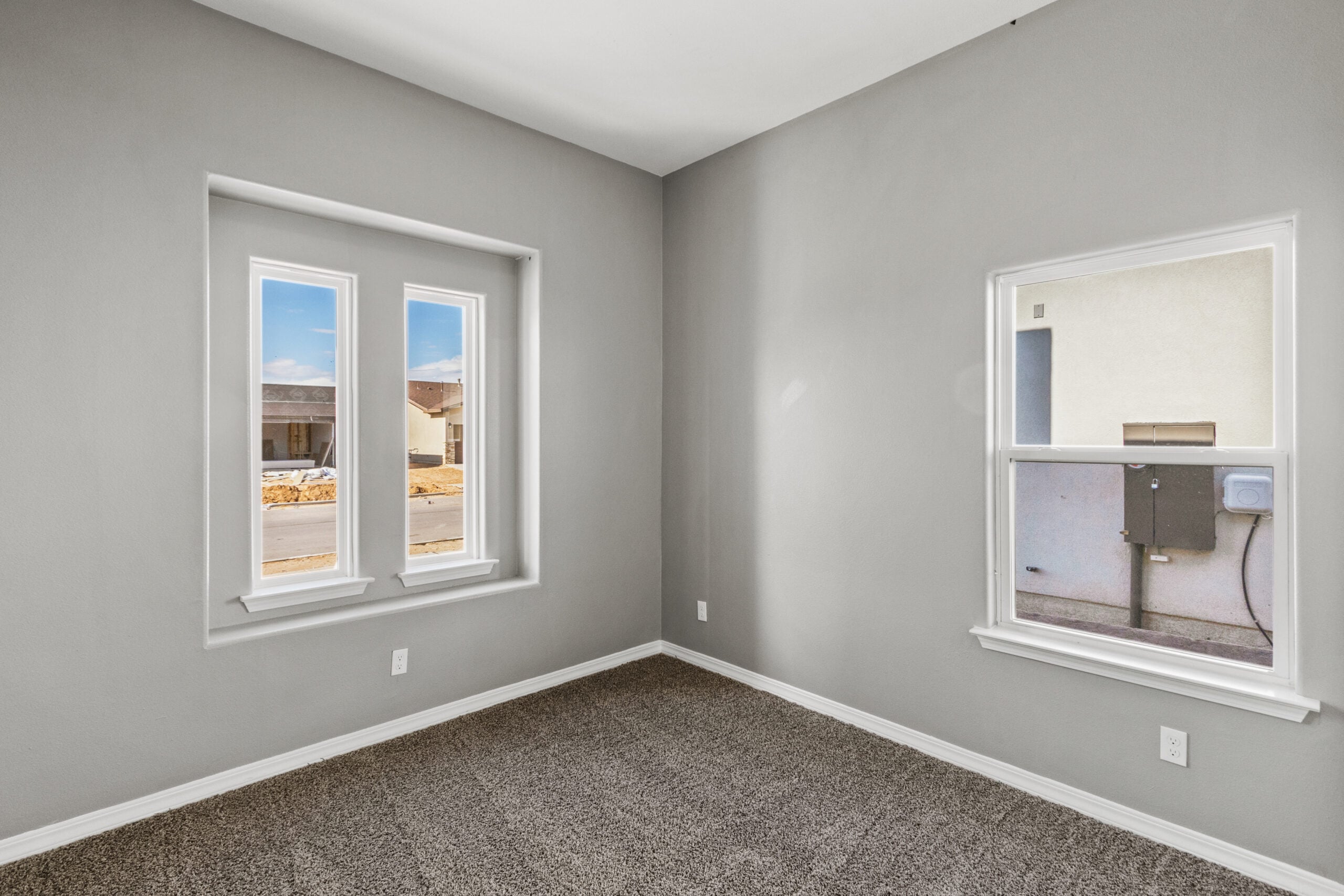 This alternate angle of The Poplin’s primary bedroom highlights the built-in closet with paneled double doors, plush carpet, and an open view into the hallway, offering a clear look at the home’s thoughtful layout and transitional flow.