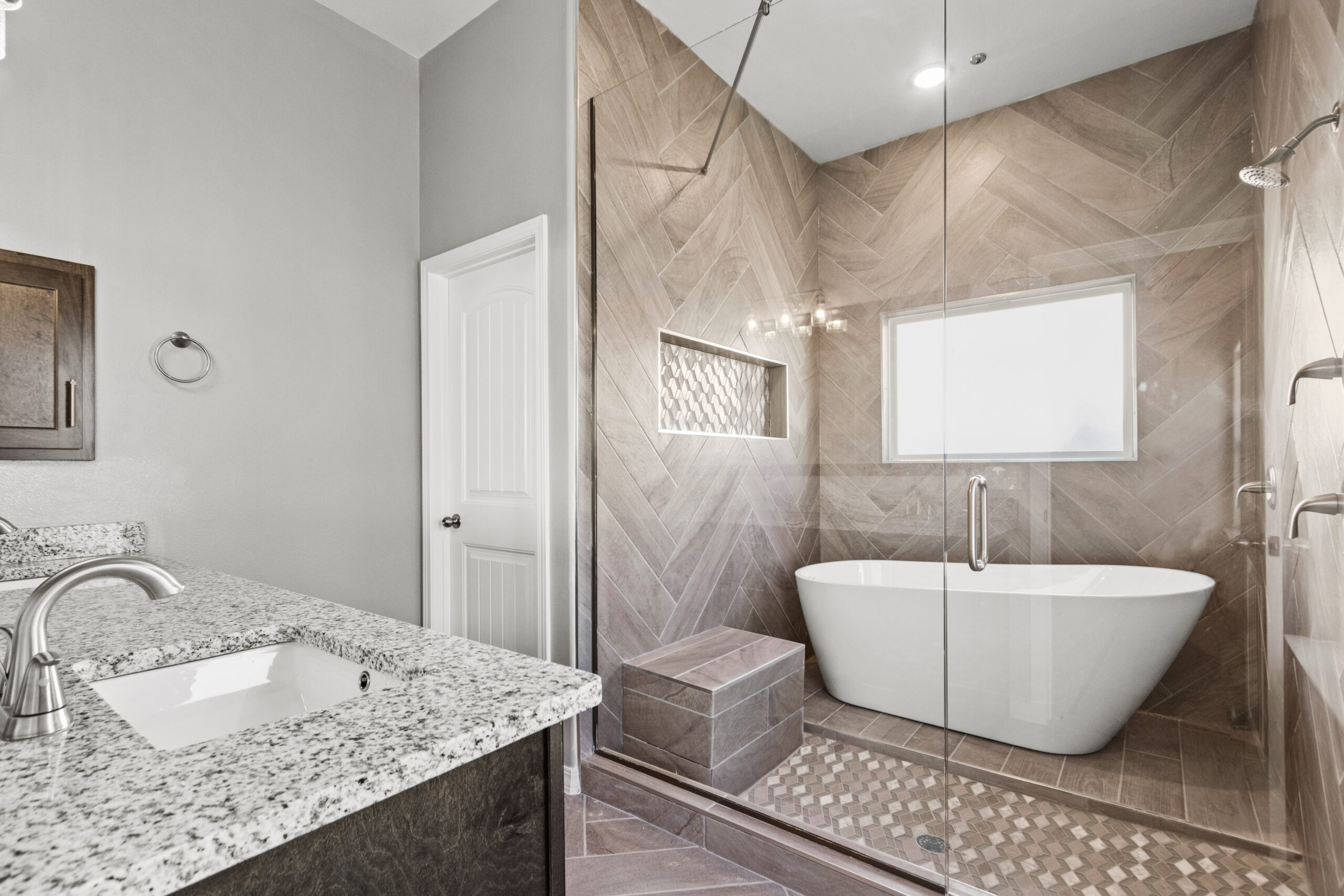 Luxurious bathroom in The Poplin with freestanding tub and glass-enclosed shower