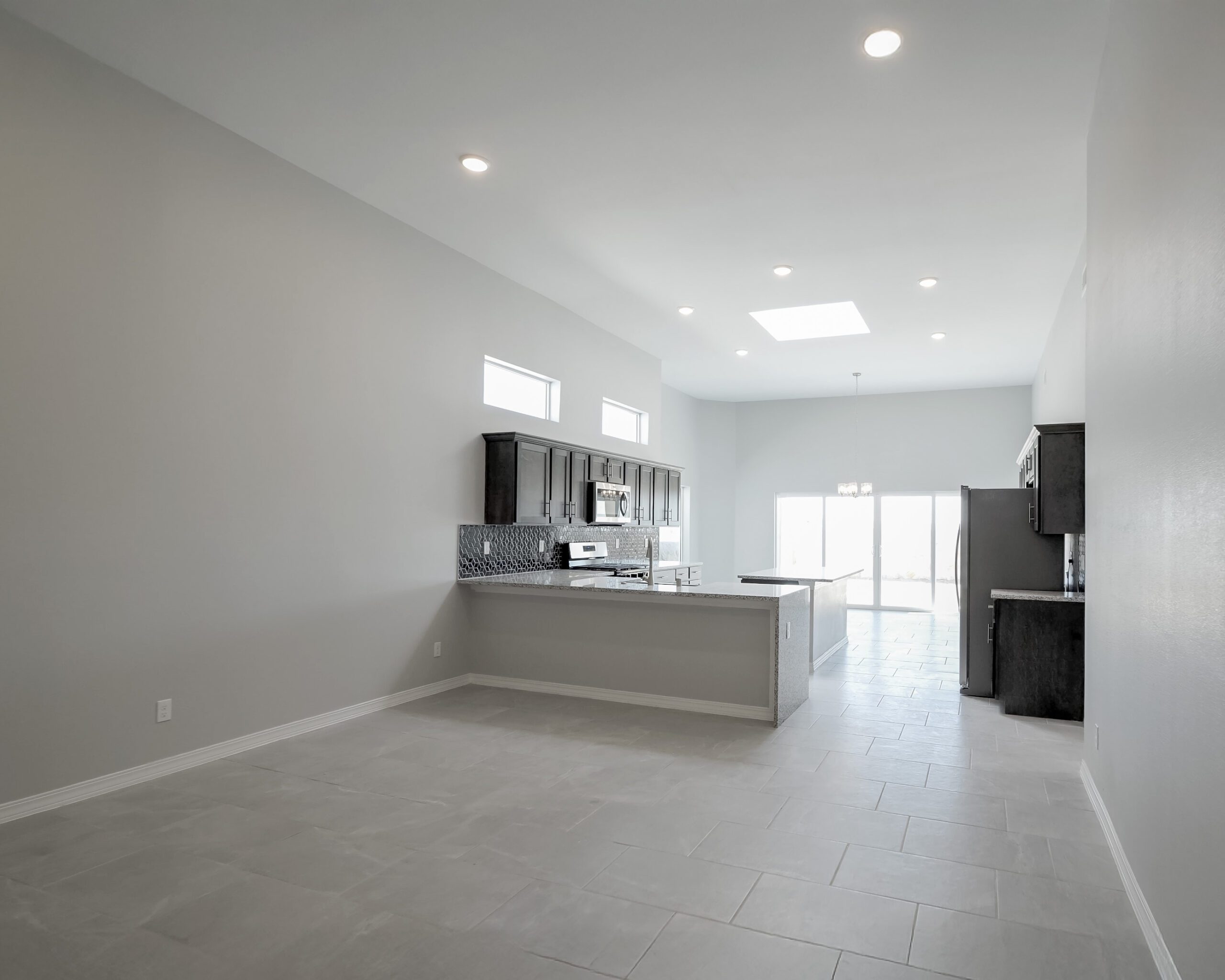 The Lotus open concept living room and kitchen area with sliding glass doors leading to the patio.