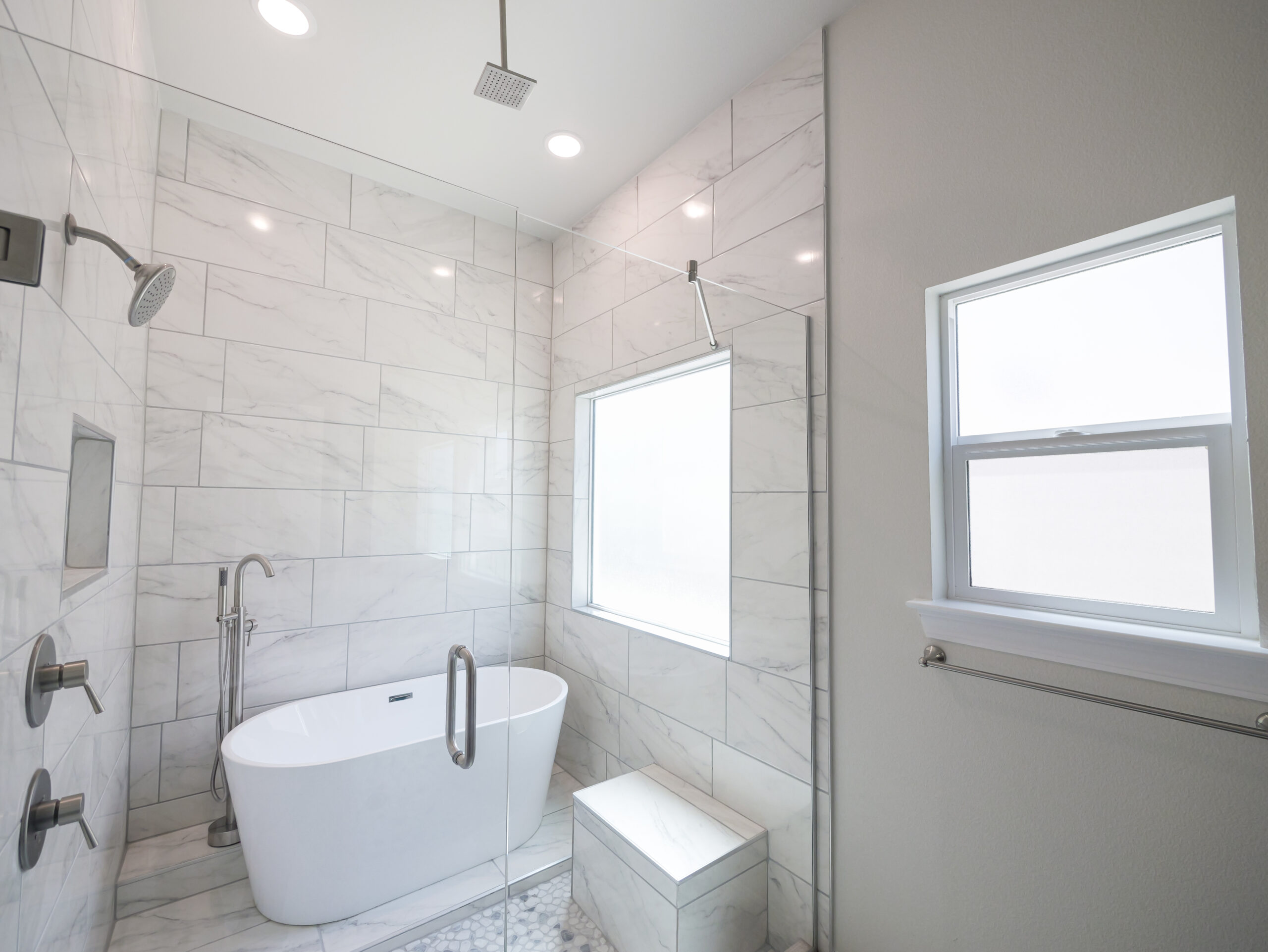 Hibiscus Master Bathroom with tile and lots of natural lighting. Walk-in shower with free standing tub.
