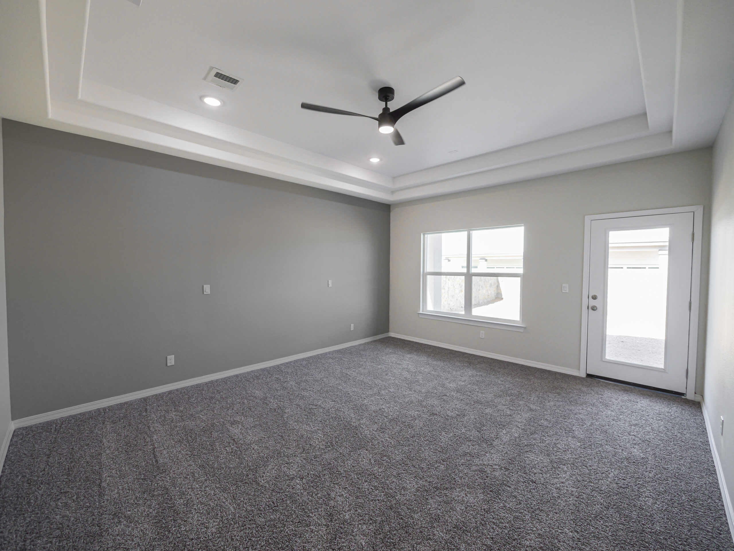Hibiscus master bedroom with tray ceilings and a door to small private secondary patio in the backyard.