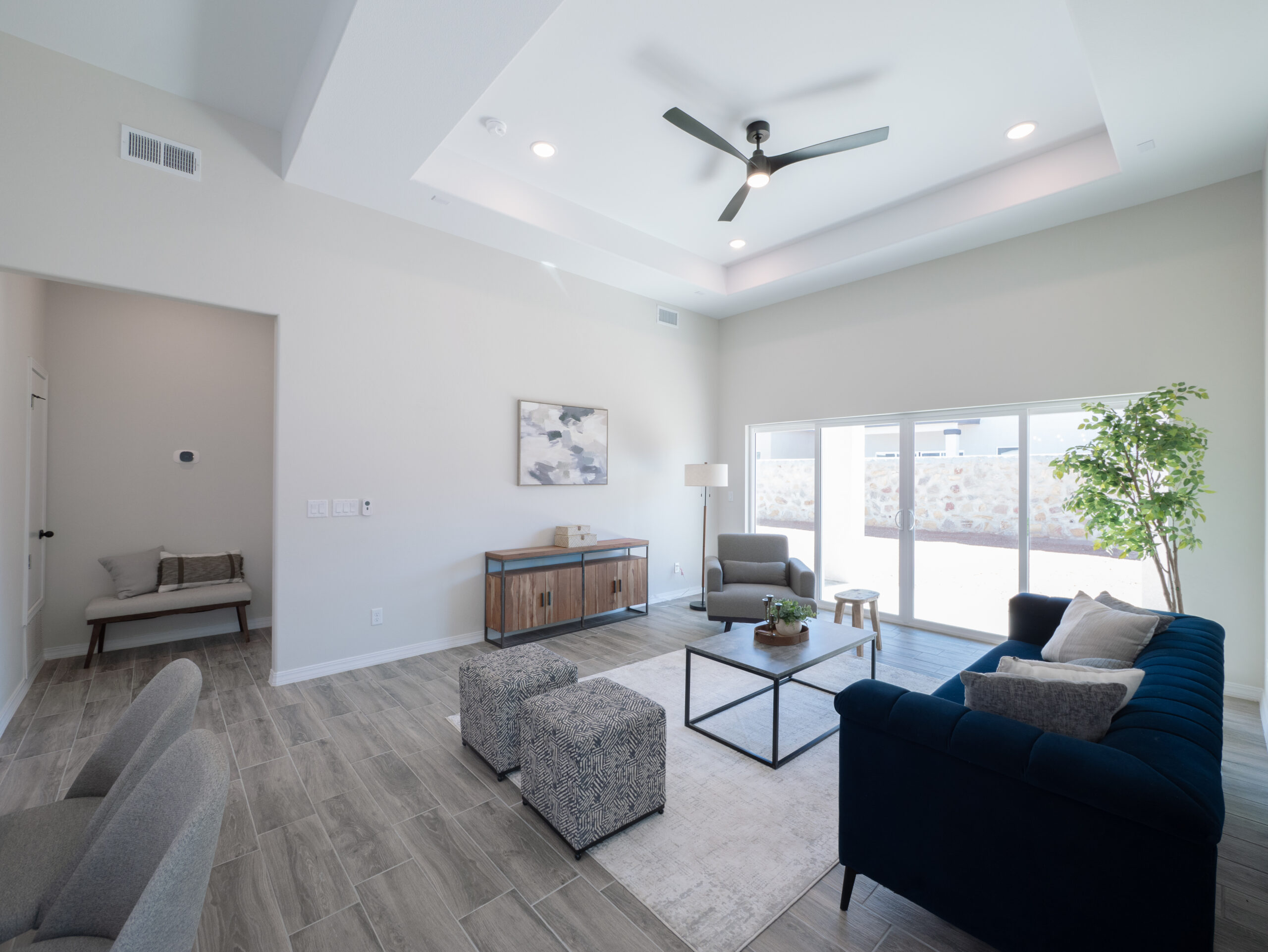 The Chai Living Room with glass sliding doors that lead to the backyard. There are tray ceilings.