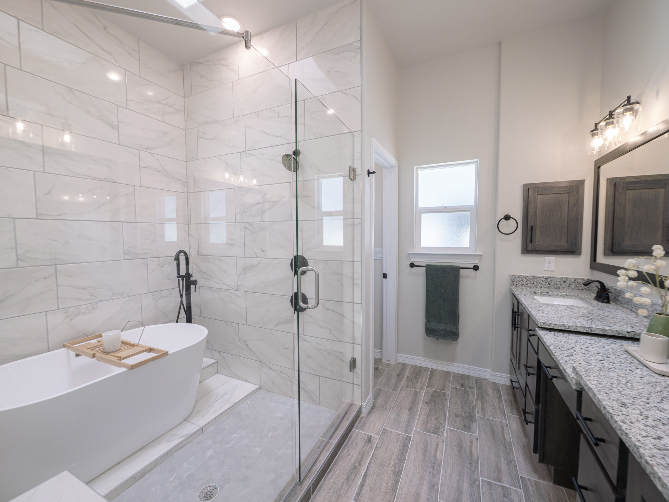 The Chai Master Bathroom with dark wood countertops, stainless steel appliances, and a walk-in shower. The tub is also free standing in the shower.
