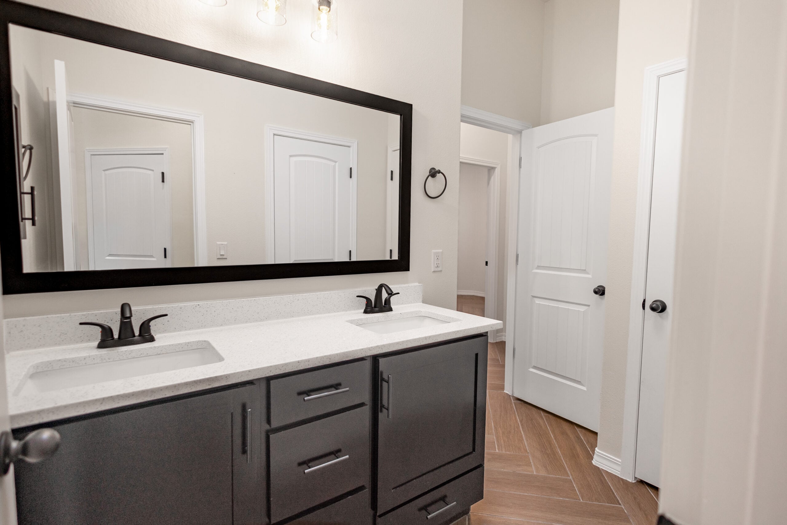 The Daisy Bathroom with a large mirror and two sinks.