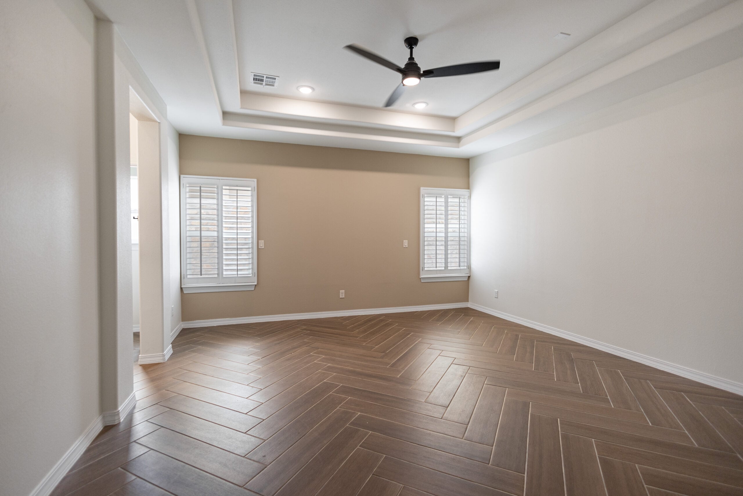 The Daisy Master Bedroom with tray ceilings and two large windows.