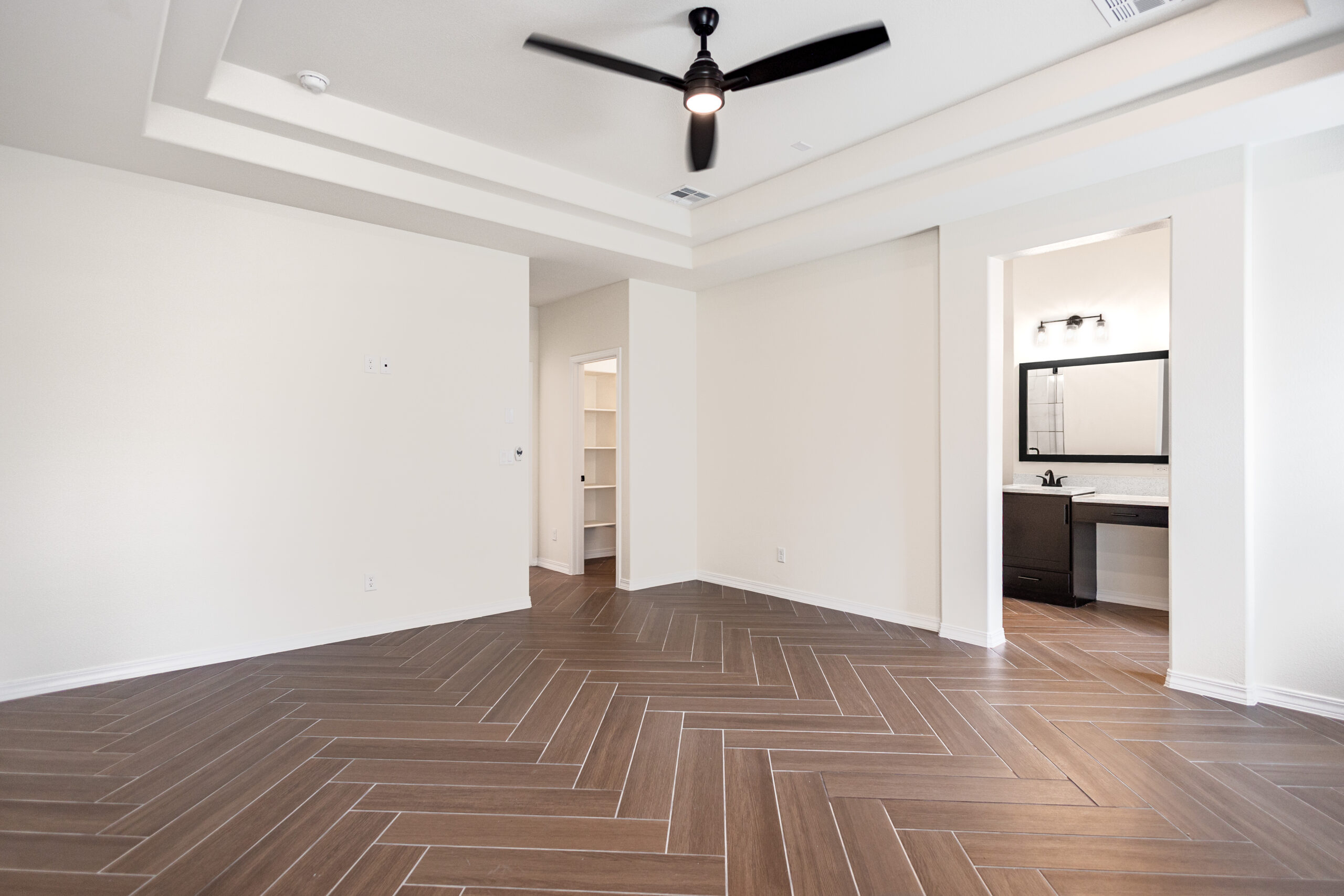 The Daisy Master Bedroom with tray ceilings and a black fan.